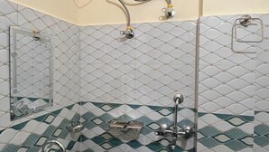 Une salle de bain avec un lavabo blanc, un miroir, des toilettes et un sèche-mains fixé au mur.