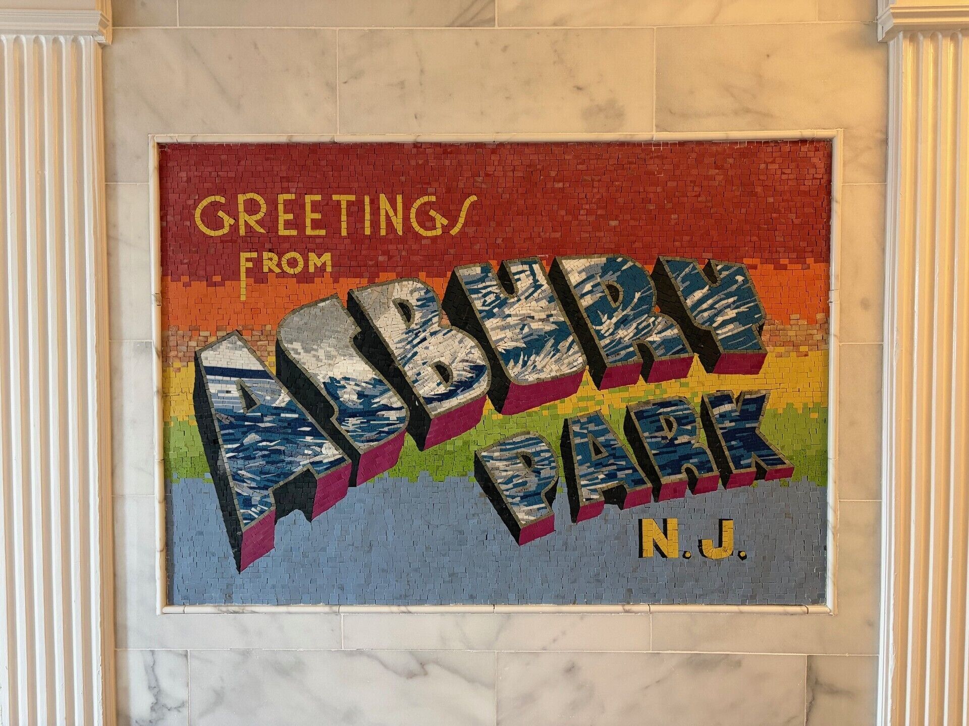 A mosaic wall with the text 'Greetings from Asbury Park, N.J.'