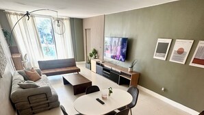 A modern living room with a sofa, coffee table, and dining area. - Modern & cozy apartment beachfront (Sunny Isles Beach)