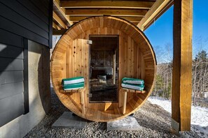Une structure de sauna en bois, dotée de bancs et d’une porte.