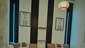 Ett hotellrum med två sängar, mörka, vertikala persienner och konstverk som hänger på väggen.