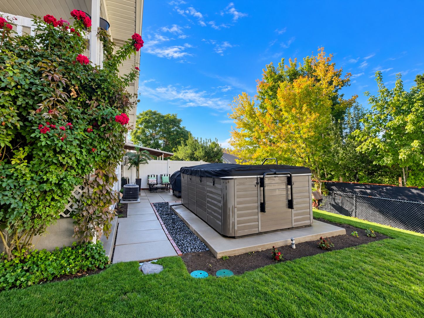 Un jardin avec une terrasse, un abri de jardin et un potager.
