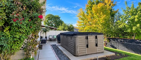 A backyard with a patio, a shed, and a garden.