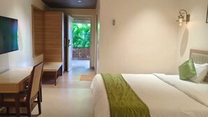 Una habitación de hotel con cama, escritorio y televisor.
