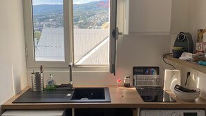 Een kleine keuken met een ingebouwde wasmachine en een compacte koelkast.