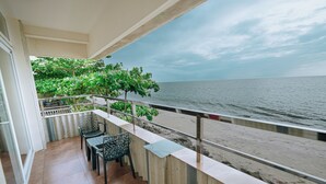 A balcony with a view of the sea, a table, chairs, and a railing. - The Cabana (Kochi)