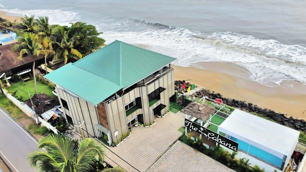 A beachfront building with a green roof, a swimming pool, and a sign reading "The Cabana." - The Cabana (Kochi)
