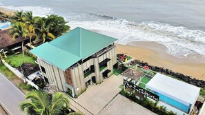 A beachfront building with a green roof, a swimming pool, and a sign reading "The Cabana." - The Cabana (Kochi)