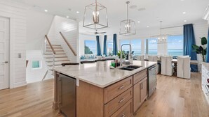 A modern kitchen with a central island, wooden cabinets, and pendant lighting. - LUX Family Teddy's Heaven - Beachfront - 6 Seater LSV - Pool-Hottub (Panama City Beach)