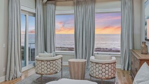 A room with a view of the ocean, two hexagonal chairs, a round wooden table, and a bed. - LUX Family Teddy's Heaven - Beachfront - 6 Seater LSV - Pool-Hottub (Panama City Beach)