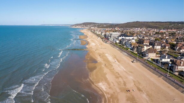 An aerial view of a coastal town with a sandy beach, a promenade, and residential buildings. - Le Petit Shamrock - exceptional villa on the beach (Cabourg)