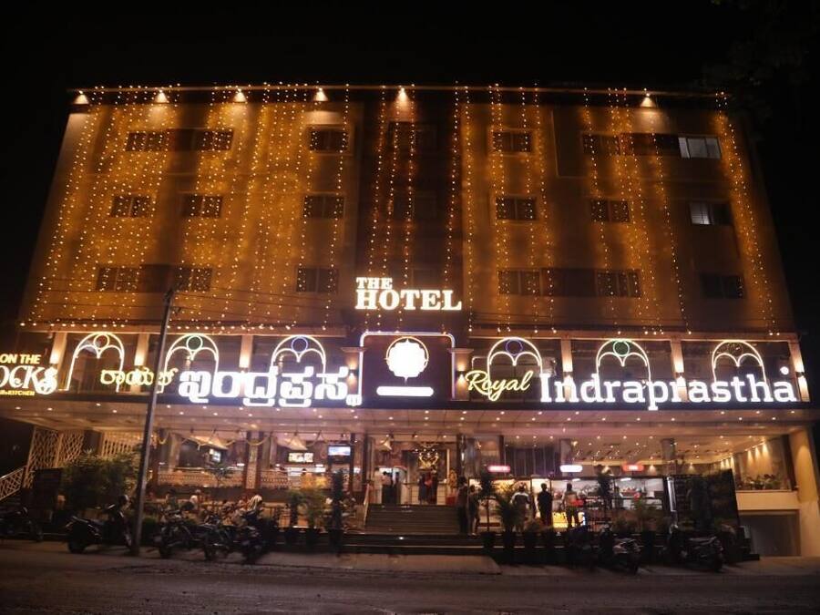 Een hotel met een bord waarop 'The Hotel Royal Indraprastha' en daaronder 'On the Rocks' staat.