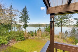 A wooden deck with a view of a lake and surrounding trees. - Private Beach, Stunning Views! Home on Oyster Bay! (Olympia)