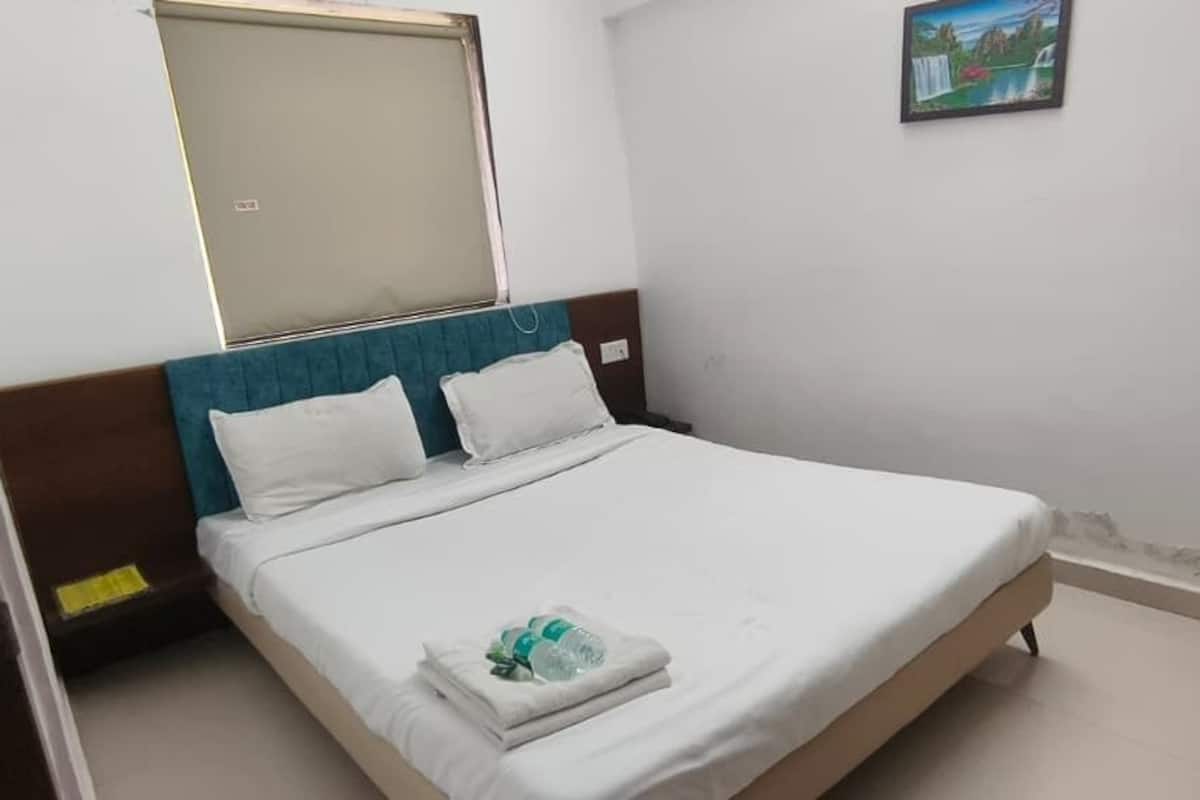 Una habitación de hotel con una cama, un ventanal y un cuadro en la pared.
