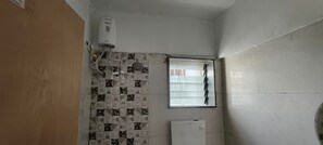 Un baño con pared de azulejos, una ventana y un radiador blanco.