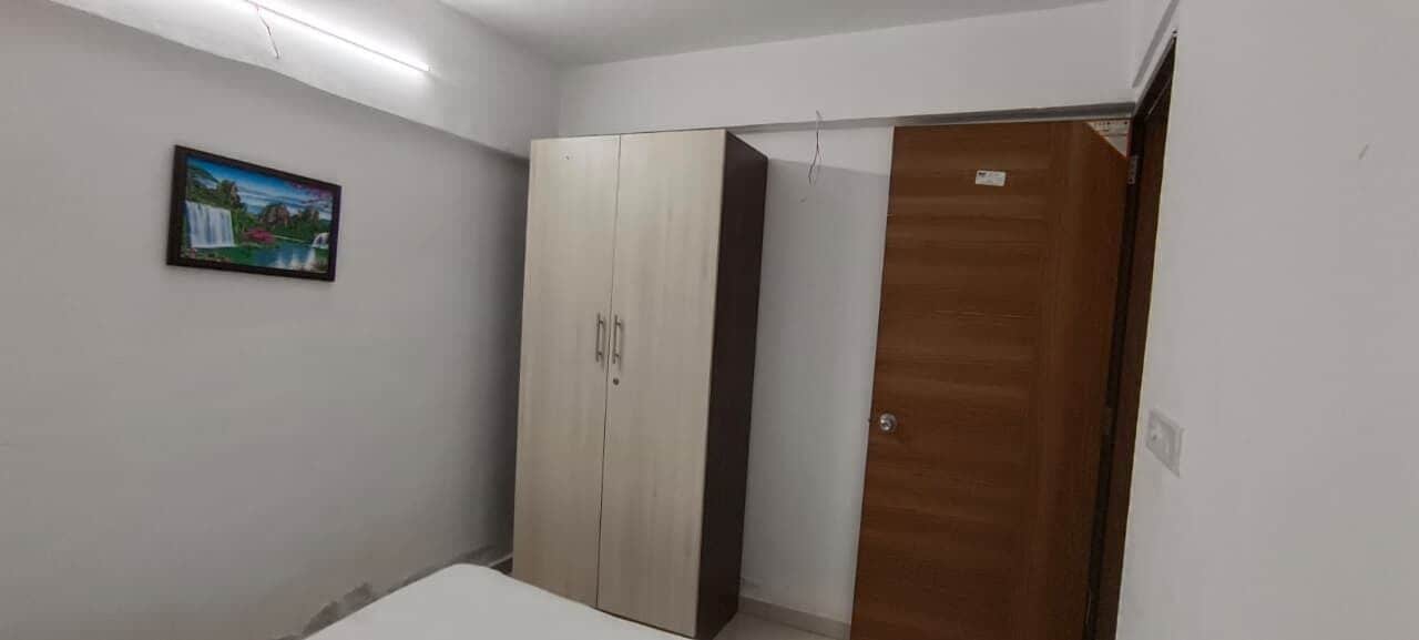 Una habitación con un armario, una puerta de madera y un cuadro en la pared.