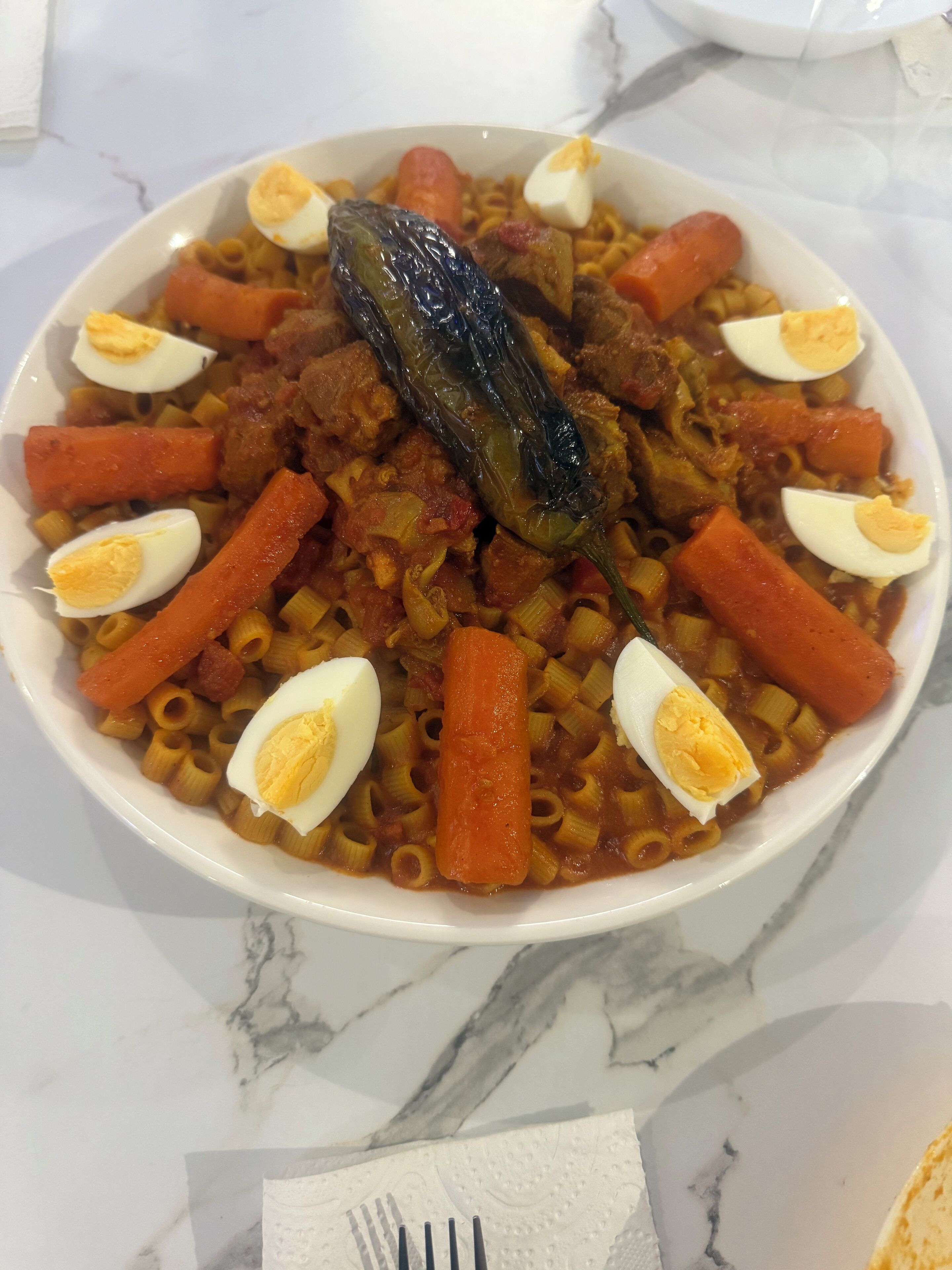 Un plato de pasta con verduras y huevos.