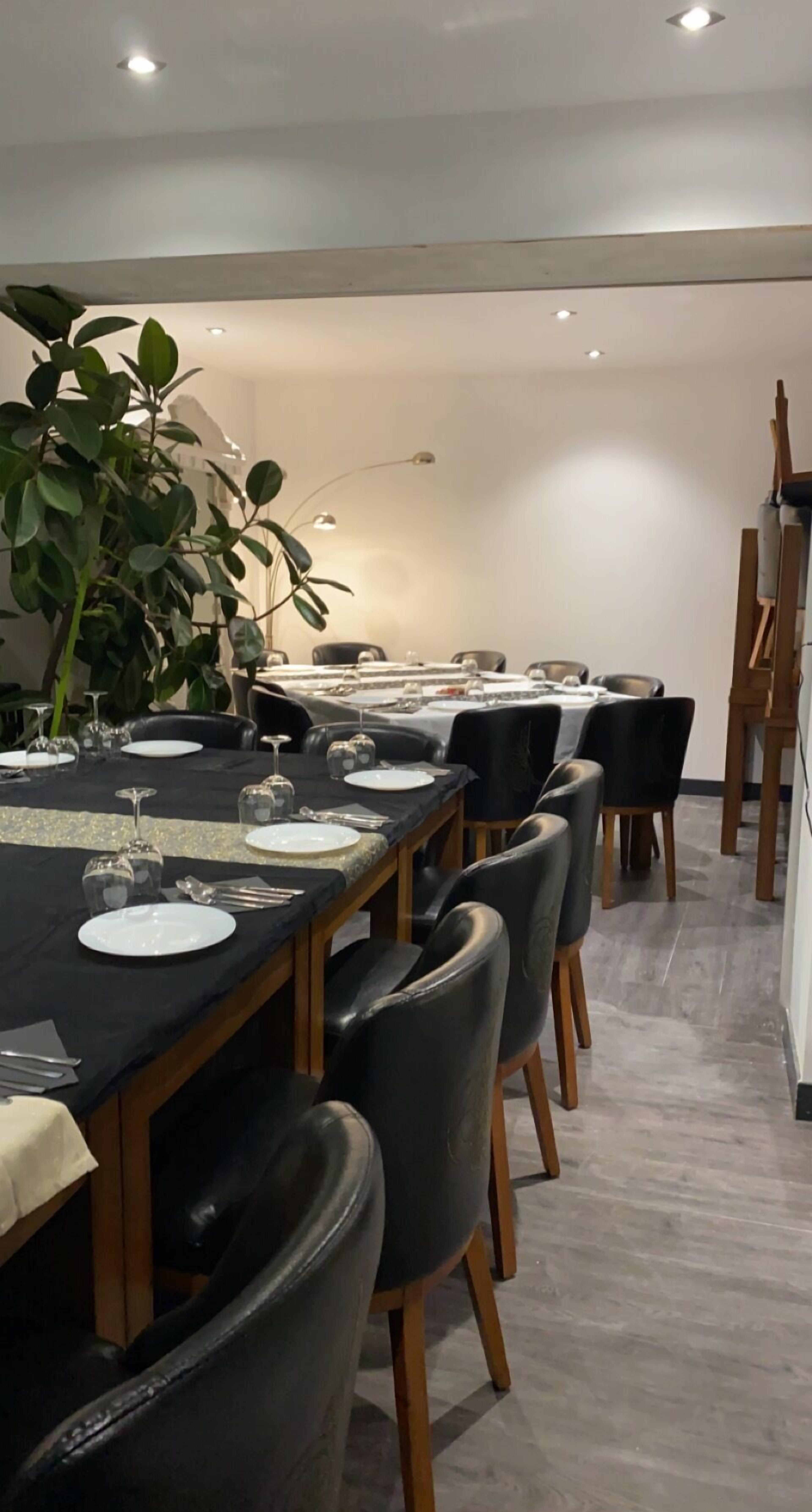 Un comedor con una mesa larga dispuesta para seis personas, rodeada de sillas negras.