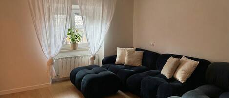 Deluxe-Apartment, Stadtblick | Wohnbereich | 65-Zoll-Smart-TV mit Digitalempfang