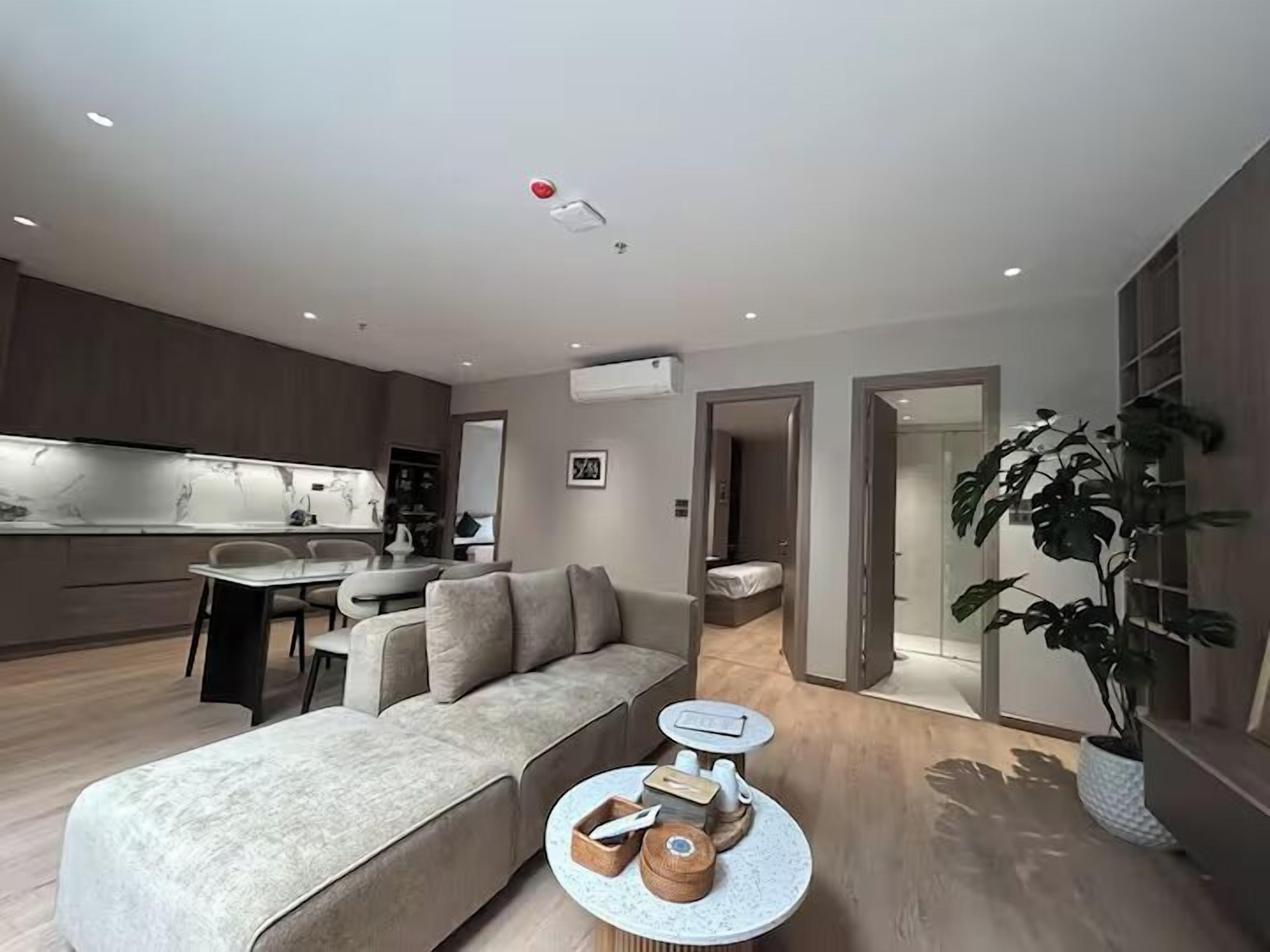 Ein modernes Wohnzimmer mit Sofa, Couchtisch und Essbereich mit Tisch und Stühlen.