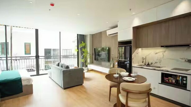 A modern apartment with a dining area, kitchen, and a balcony with a sofa. - The Lumi Apartments by XOI Residences (Hanoi)