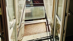 A balcony with a view of the cityscape, a clear sky, and a sun shining through the window. - Milan Bicocca Apartment, cozy luxury apartment, comfortable particular (Cinisello Balsamo)
