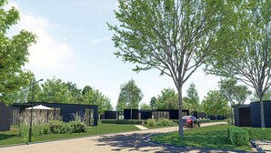 Et moderne boligområde med en anlagt sti, grønt og moderne bygninger.