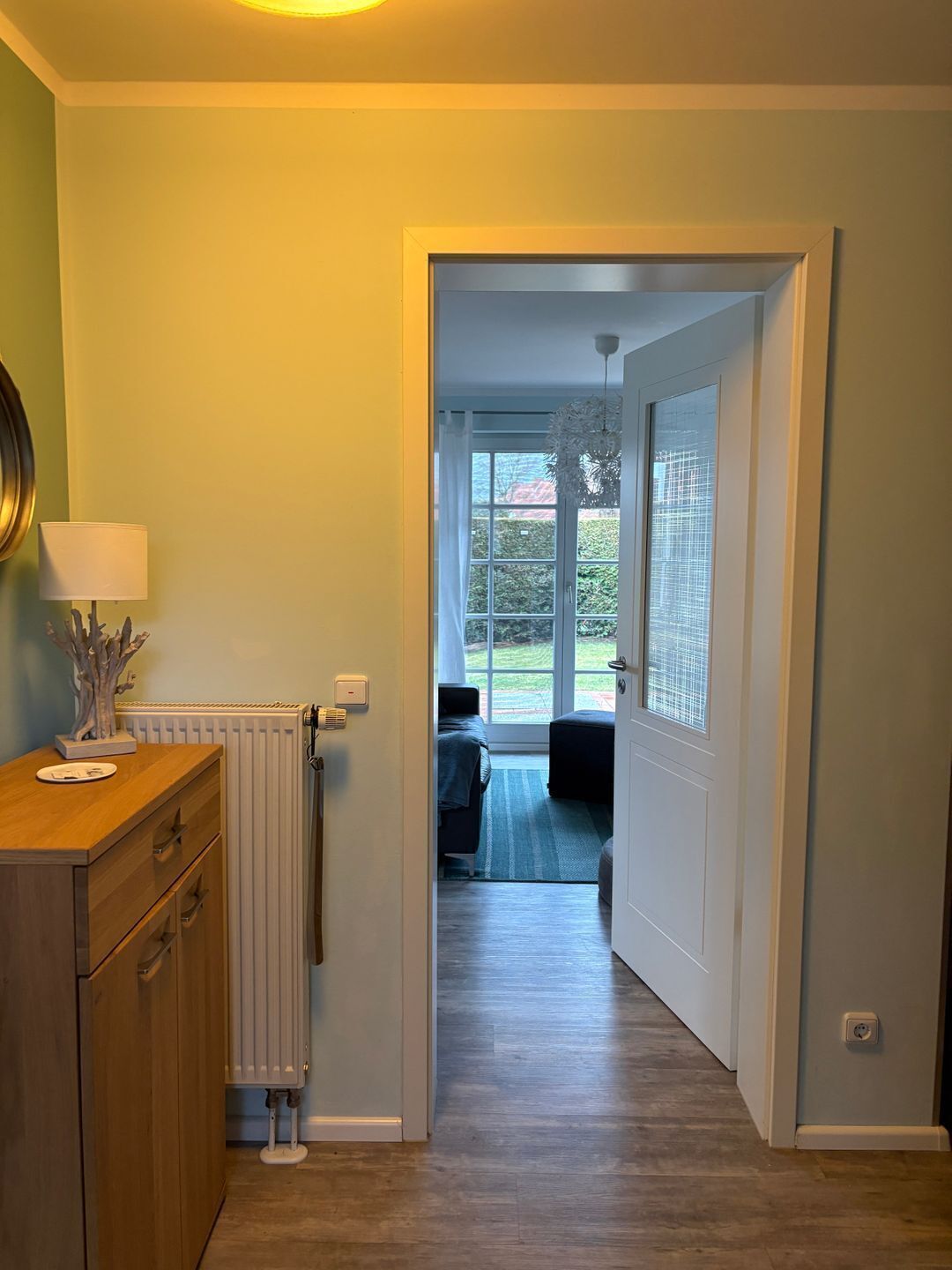 Ein Flur, der zu einem Schlafzimmer mit Blick ins Freie führt.