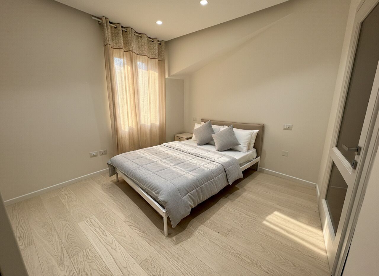 Un dormitorio con cama, cortinas y una puerta.