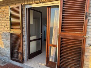 A building entrance with a glass door and wooden shutters. - Luce Luxury with panoramic terrace (Assisi)