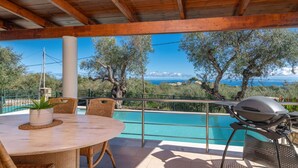 A covered outdoor area with a pool, wooden ceiling, and a view of the sea. - Villa Gisele With Private Pool (Zakynthos)