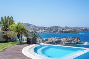 A curving infinity pool with a clear view of the ocean and distant town. - Caldera Blue Villa!! (Malevizi)