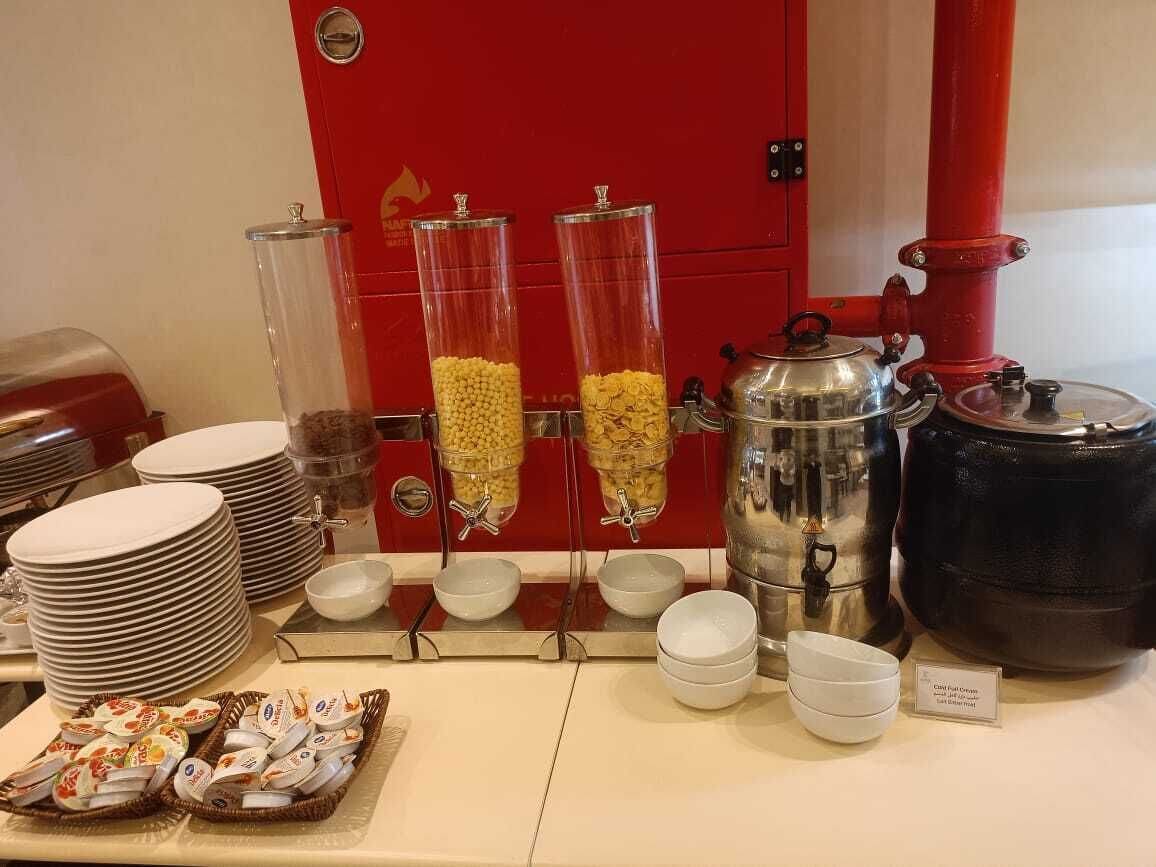 A buffet setup with food dispensers, serving dishes, and a coffee pot.
