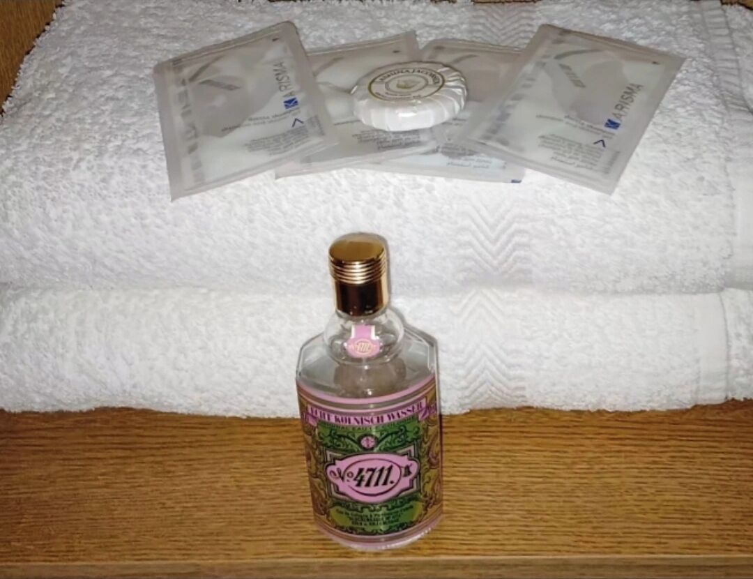 A bottle of alcohol on a wooden surface with a white towel in the background.
