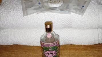 A bottle of alcohol on a wooden surface with a white towel in the background.