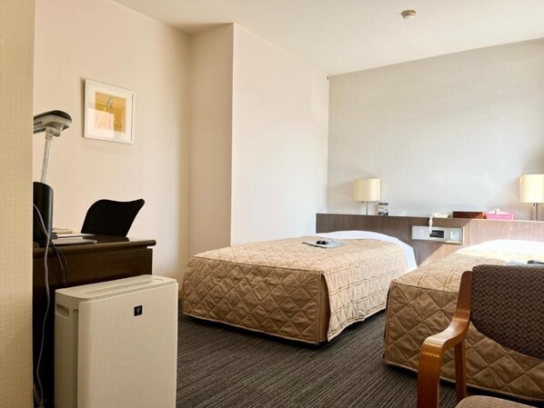 A hotel room with two beds, a desk with a chair, a desk lamp, a small refrigerator, and a wall-mounted mirror. - NAKAMURA DAIICHI HOTEL (Shimanto)