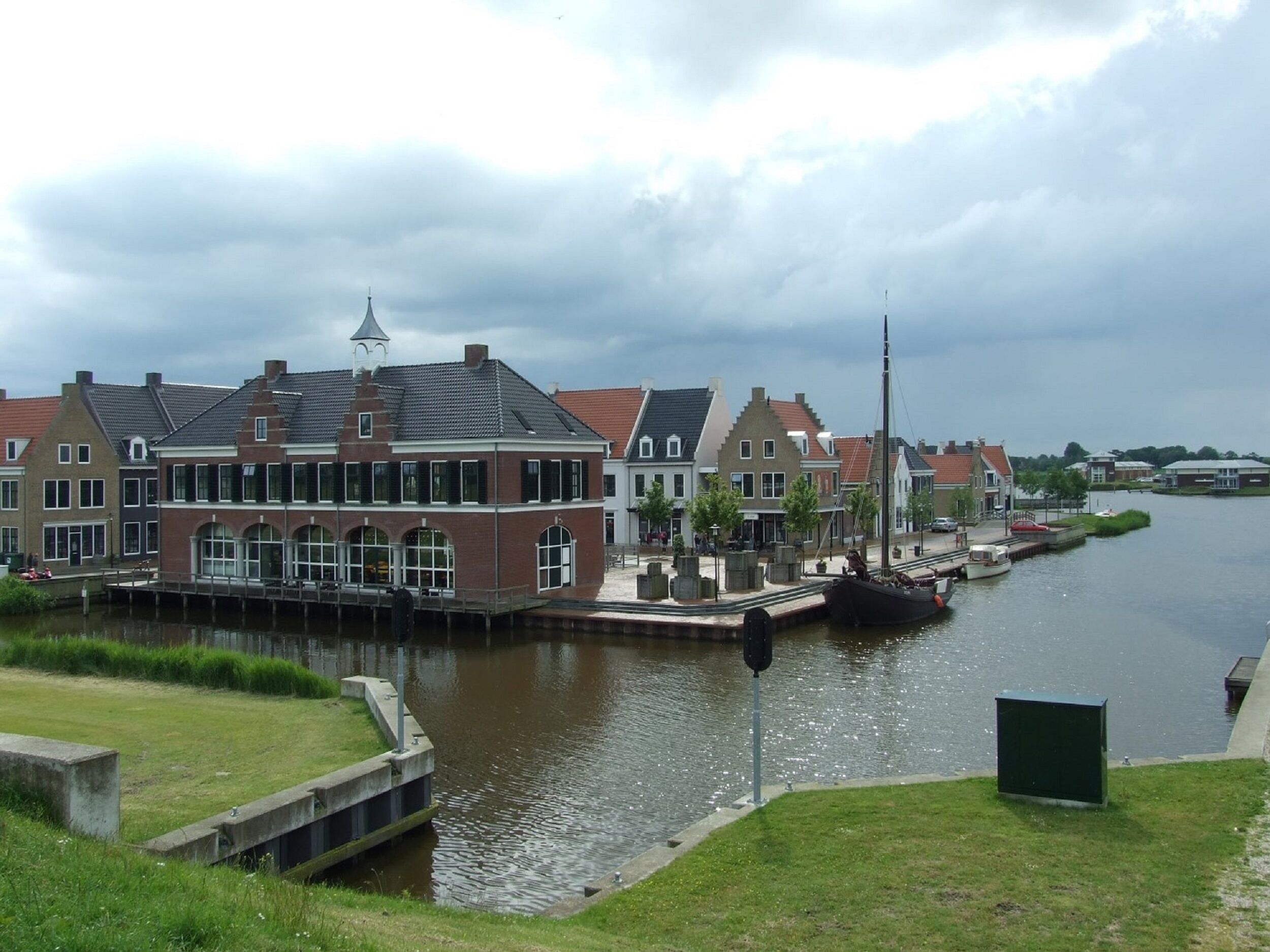 Ein Gebäude am Kanal mit traditioneller Architektur, das einen markanten Turm und große Fenster aufweist.