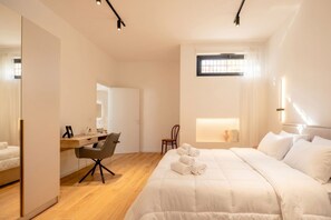 A modern hotel room with a large bed, a desk, a chair, a mirror, and a small window. - MareVista Garden - Private Garde and Parking (Bari)