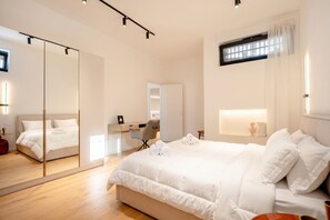 Ein modernes Schlafzimmer mit einem großen Bett, einem Schreibtisch und einem Spiegel.