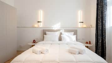 Una habitación de hotel moderna con una cama grande, dos mesitas de noche y una pequeña mesa redonda.