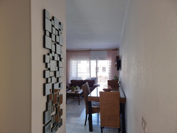 Un espace repas comprenant une table, des chaises et un panneau décoratif fixé au mur.