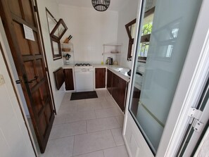 A compact kitchen with a gas stove, dishwasher, and white tiled walls. - Welcoming house in L'Escala, 1500m from the beach, perfect for families (L'Escala)