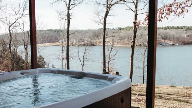 Un bain à remous avec vue sur un lac et des arbres.