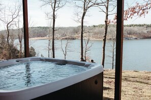 Un jacuzzi con vistas a un lago y árboles.