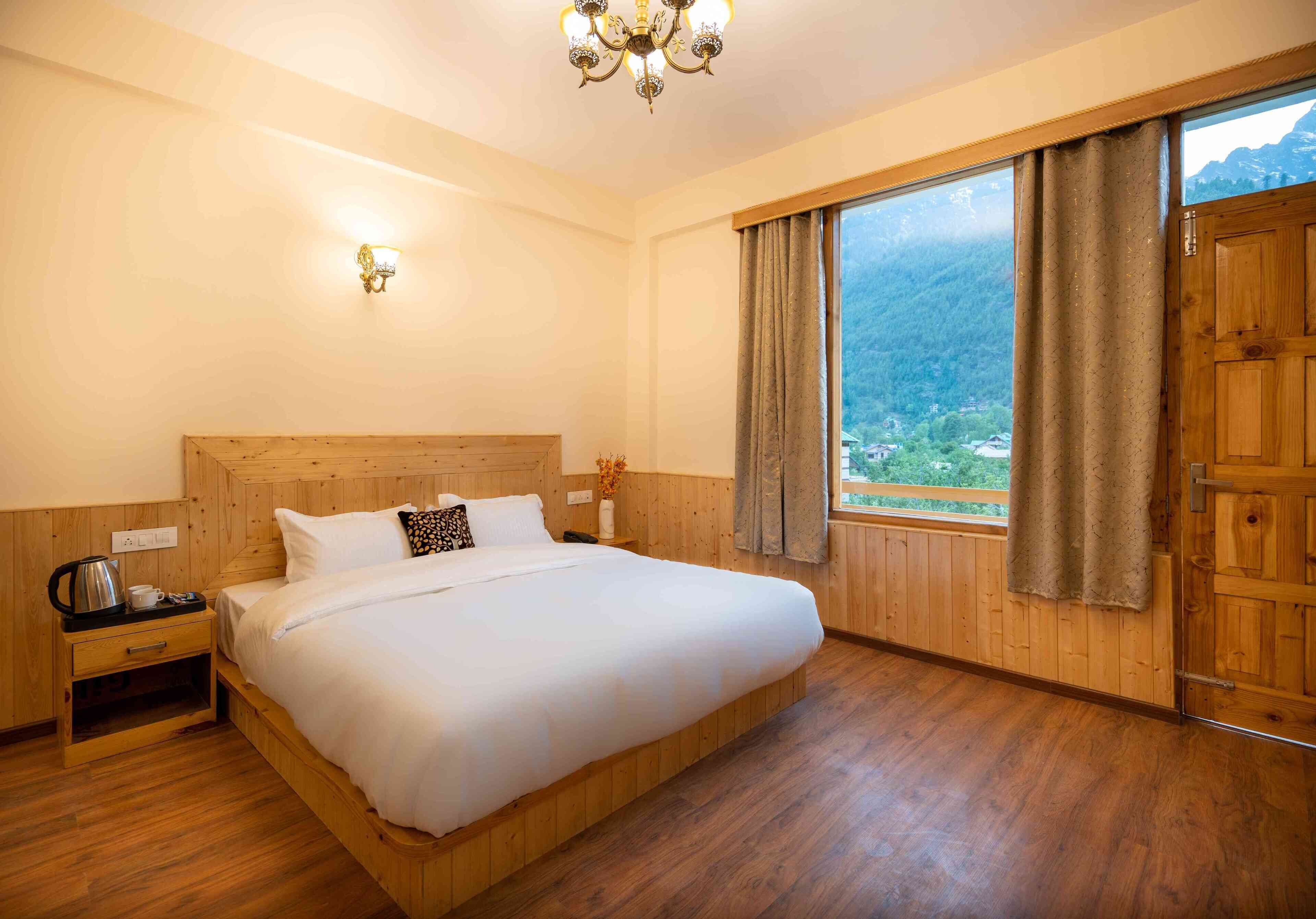 Un dormitorio con cama de madera, una mesita de noche, una lámpara y una ventana con cortinas.