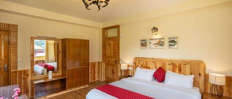 Une chambre à coucher avec un grand lit, une armoire en bois, un miroir et un lustre.