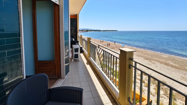 Ein Balkon mit Meerblick, einem Stuhl und einem kleinen Tisch.