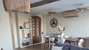 A living room with a sofa, coffee table, and a dining area with a table and chairs.