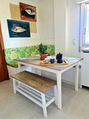 A small kitchen with a wooden table, bench, and a potted plant. - Villa La Yuca: private pool, barbecue area, and private parking (pet-friendly) (Los Alcázares)