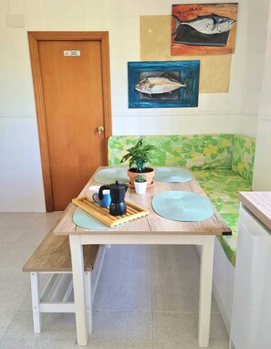 A small kitchenette with a wooden table, a coffee maker, a potted plant, and a wall-mounted fish painting. - Villa La Yuca: private pool, barbecue area, and private parking (pet-friendly) (Los Alcázares)